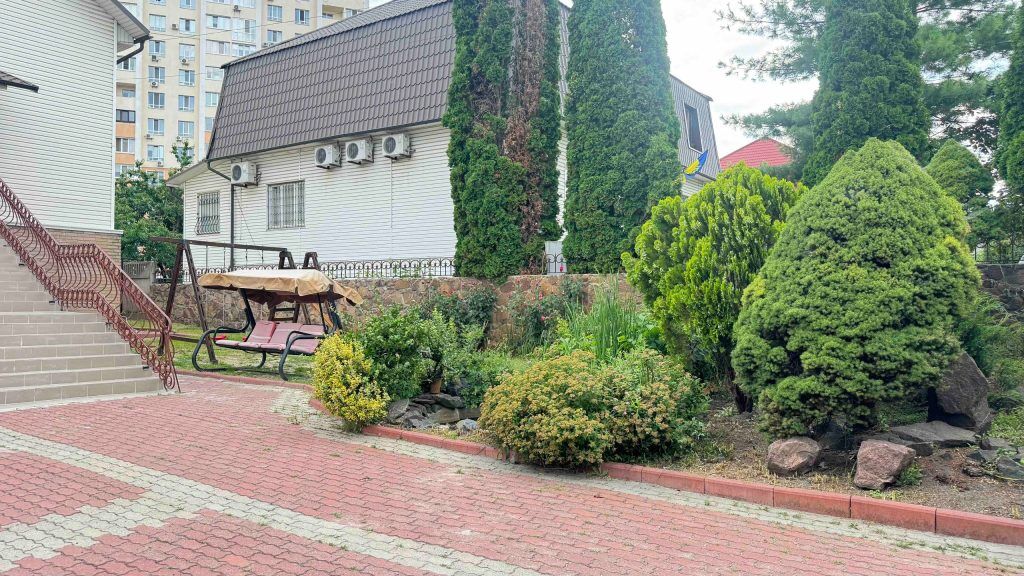 Ухоженный двор с качелями и клумбами, пансионат на Жулянской